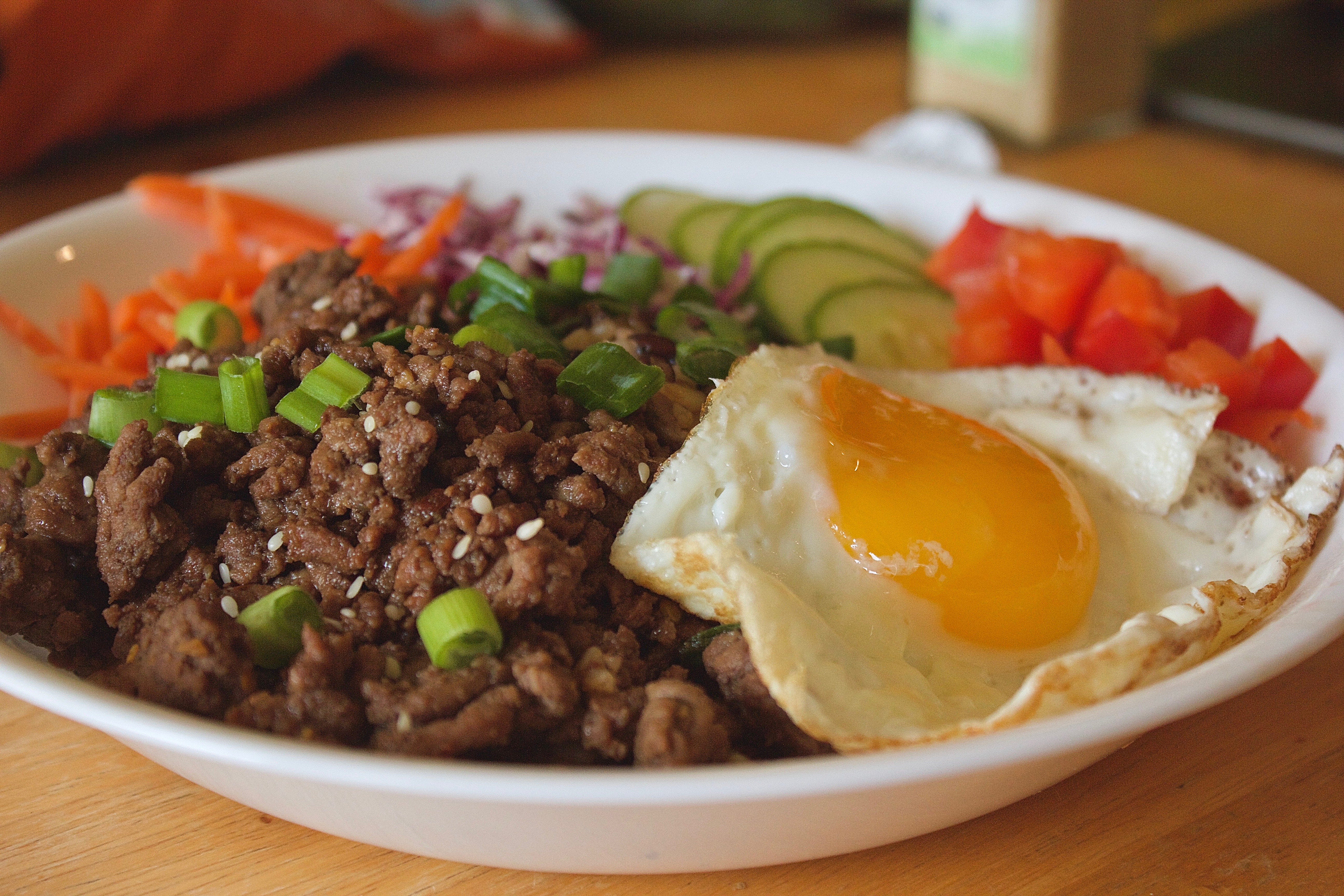 Bulgogi beef over rice with scallions and sesame, pear marinade gloss, Natural window light, ivory linen, handmade ceramic, shallow depth of field, no text, no logo, no watermark, fine-dining magazine photograph. Bulgogi Beef Bowl