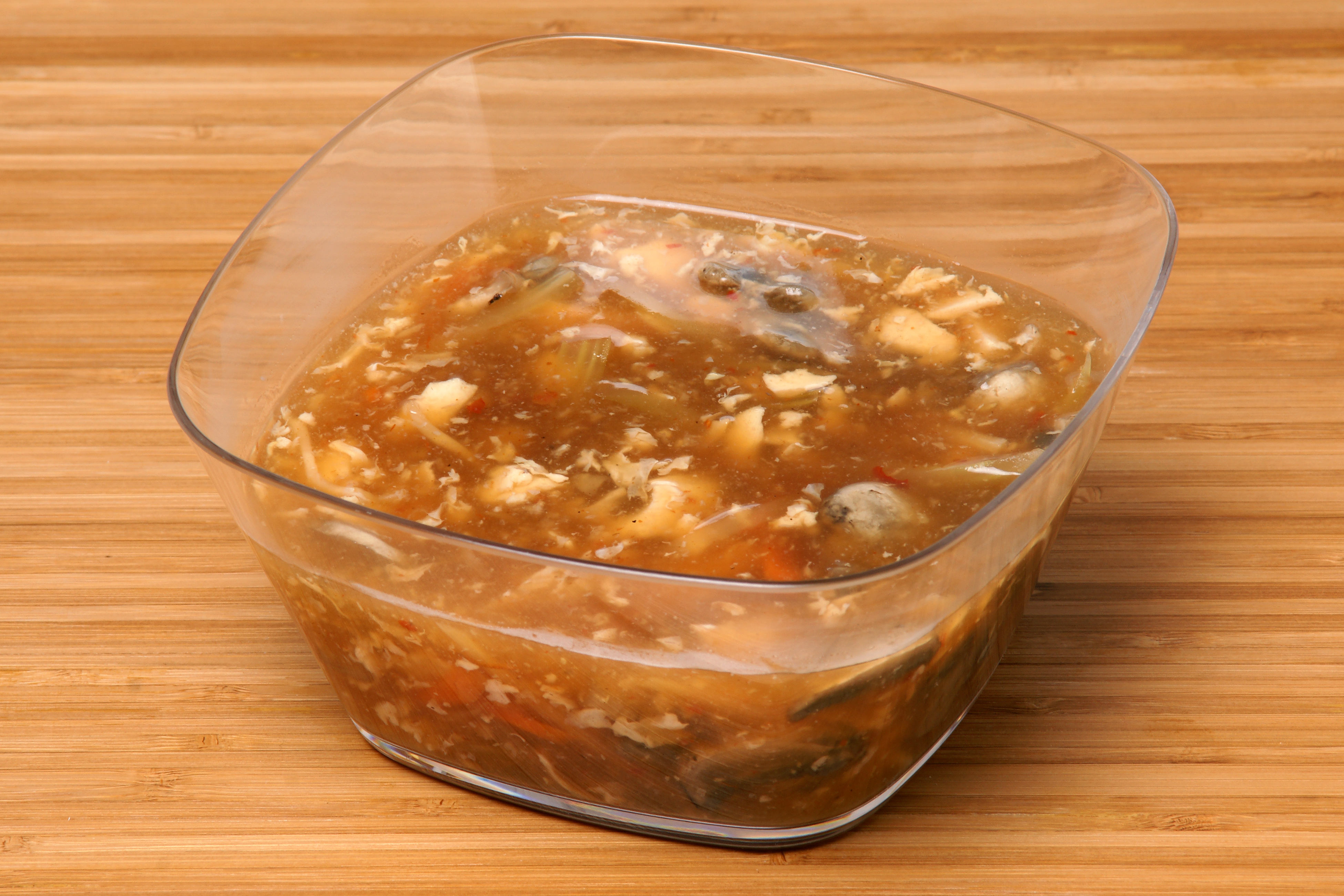 Hot and sour soup with tofu ribbons, wood ear, egg threads, and scallion, Natural window light, ivory linen, handmade ceramic, shallow depth of field, no text, no logo, no watermark, fine-dining magazine photograph. Hot and Sour Soup