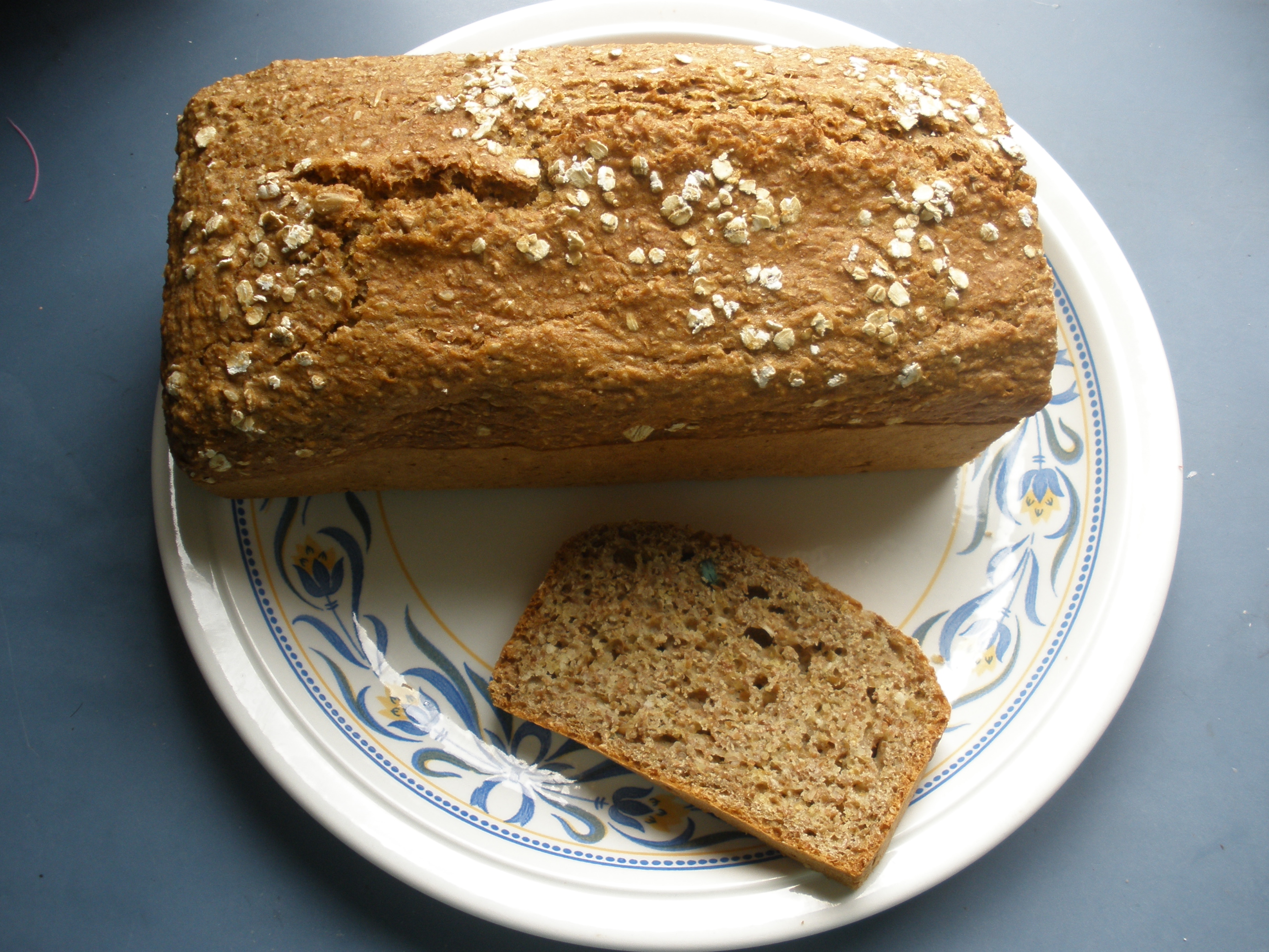 Photoreal photograph of the finished dish Brown soda bread (soda bread), the actual plate from Ireland, handmade ceramic, natural window light, shallow depth of field, no text, no logo, no people, Natural window light, ivory linen, handmade ceramic, shallow depth of field, no text, no logo, no watermark, fine-dining magazine photograph. Brown soda bread