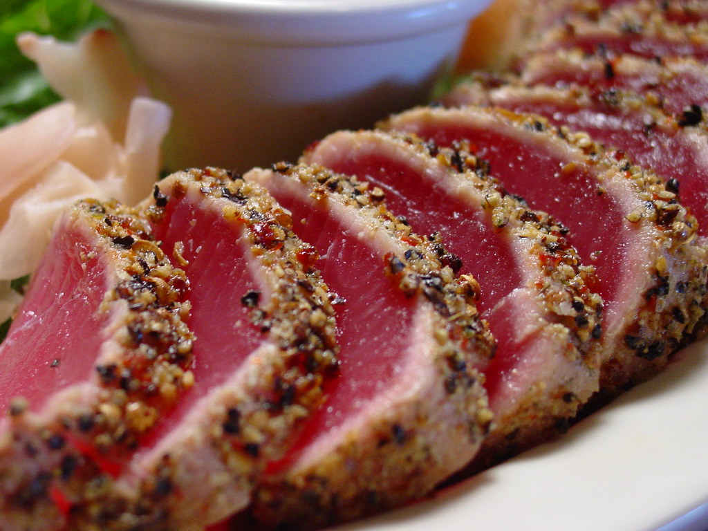 Photoreal photograph of the finished dish Grilled tuna (ati), the actual plate from Kiribati, handmade ceramic, natural window light, shallow depth of field, no text, no logo, no people, Natural window light, ivory linen, handmade ceramic, shallow depth of field, no text, no logo, no watermark, fine-dining magazine photograph. Grilled tuna