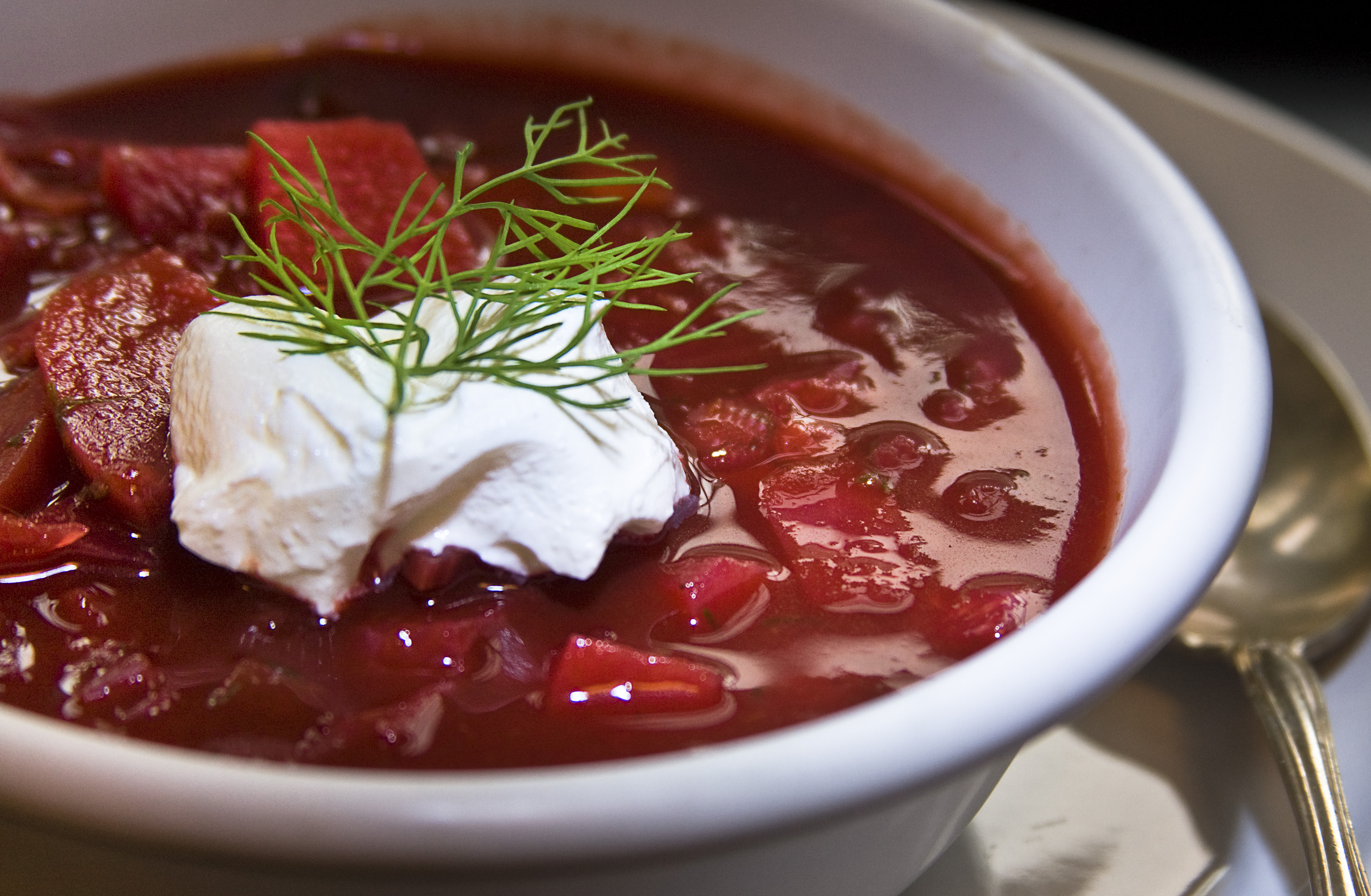 Photoreal photograph of the finished dish Borscht (борщ), the actual plate from Russia, handmade ceramic, natural window light, shallow depth of field, no text, no logo, no people, Natural window light, ivory linen, handmade ceramic, shallow depth of field, no text, no logo, no watermark, fine-dining magazine photograph. Borscht